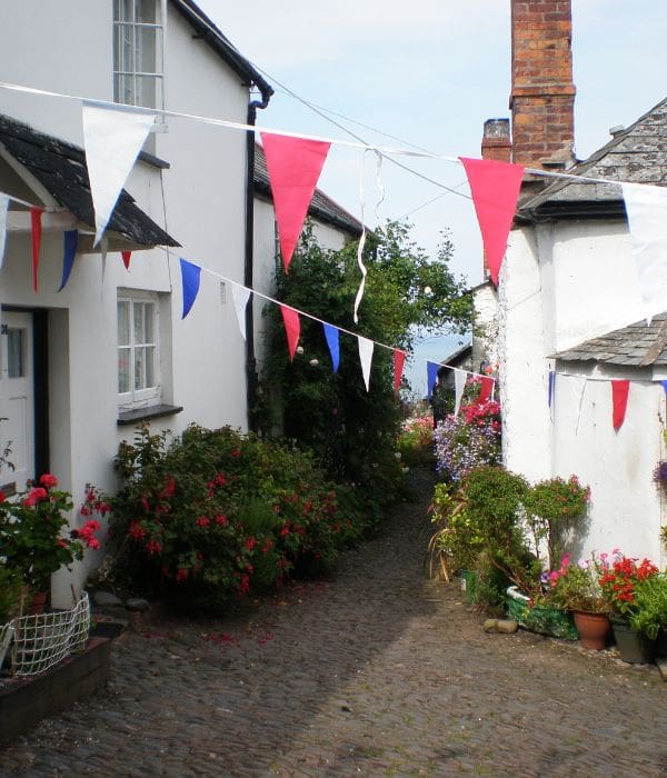 View between two cottages in Clovelly with red white and blue bunting