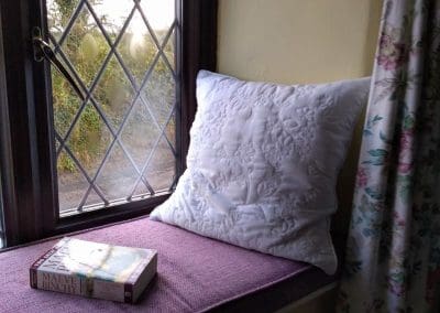 a cosy window seat with book at Sylvies north devon holiday cottage